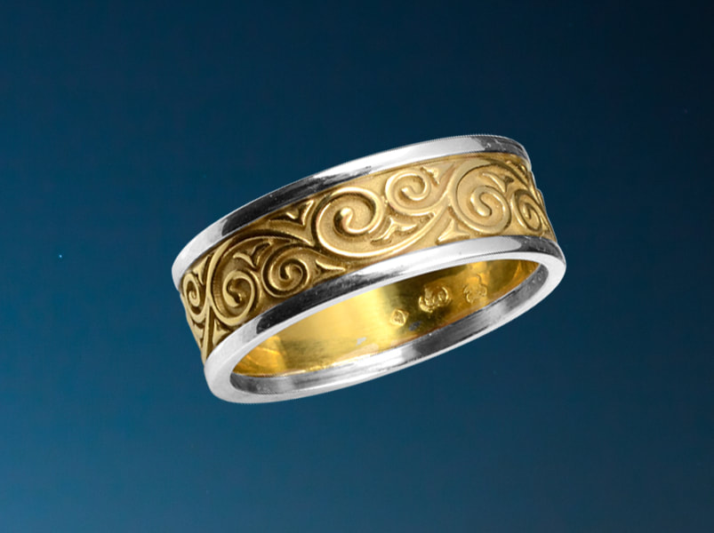 Two tone gold wedding band with scroll work pattern 